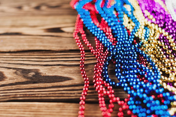 Heap of shiny colorful beads on old wooden table. Christmas or New Year or other holiday celebration concept