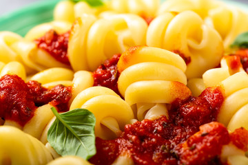 Fancy organic pasta Trattole with tomato sauce and basil. Healthy italian food concept. Close up.