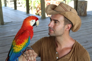 Obraz premium Handsome man holding a macaw 