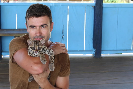 Man holding baby wild feline 