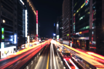 Fototapeta na wymiar Blurred cityscape at night with traffic lights