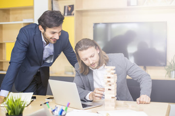 Team of young business people build a wooden construction in the office
