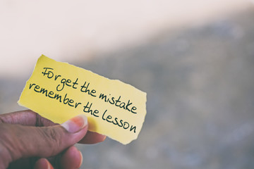 Inspirational quote on piece of paper - Forget the mistake remember the lesson.