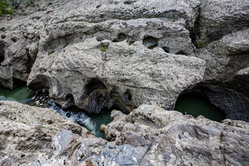 Daytime spring view taken at the amazing Devil's Canyon natural phenomenon in Bulgaria, also known as Sheytan Dere near Studen Kladenetz reservoir in Rhodope Mountain. Wonderful green waters