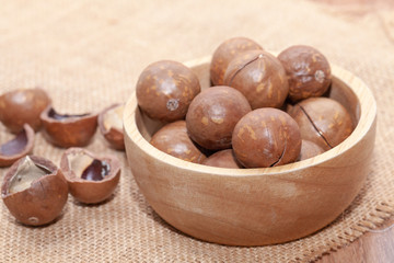 close up of organic macadamia nut on wooden bowl