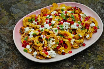Roasted delicata squash salad with goat cheese and pomegranate in the fall
