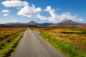 Fototapeta na wymiar Empty single track road leading towards hills in scenic landscape, Isle of Skye, Scotland