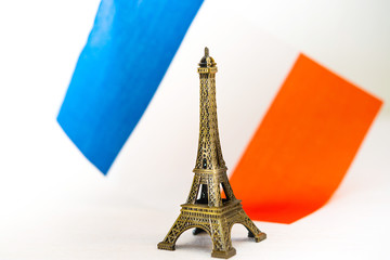 Metal Eiffel Tower and French flag on background