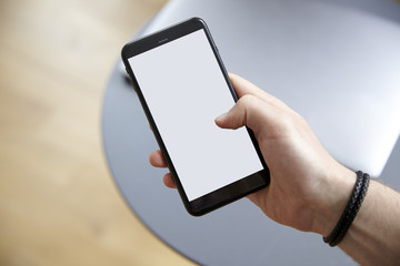 Hand holding a white blank screen smartphone