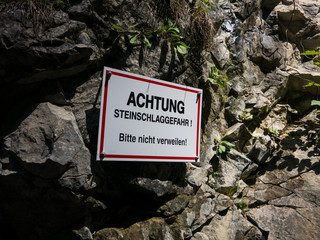 Warnschild am Fels Achtung Steinschlag Gefahr