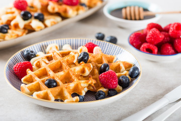 Traditional homemade belgian waffles with fresh berries and syrup