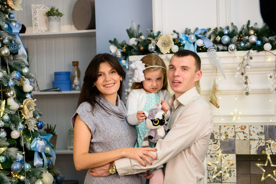 Christmas family. Mom and dad and their little daughter together at home.