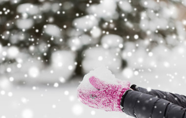 winter holidays, christmas and people concept - close up of woman holding snow outdoors
