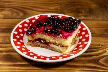 Tasty cheesecake with black currant on wooden table