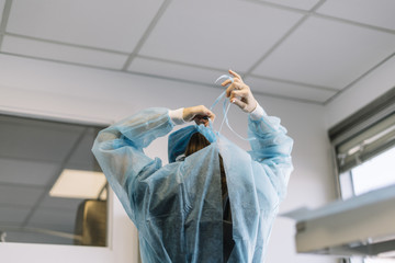 Assistant dresses a surgical gown surgeon in the operating room.contagious virus disease concept