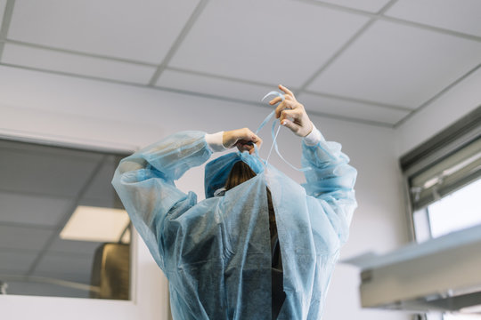 Assistant dresses a surgical gown surgeon in the operating room.contagious virus disease concept