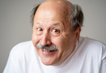Portrait of comic and crazy senior man with funny face