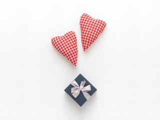 Love and Valentine day composition. Two red hearts and a gift box on a white background. Flat lay, top view, copy space
