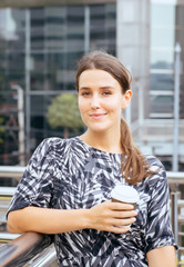 Woman holding a cup of coffee at train station,Female with positive attitude expressing energy in good time