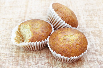 Close up group of banana cup cake bakery, some piece was bited, look delicious on wooden table background, vintage tone.