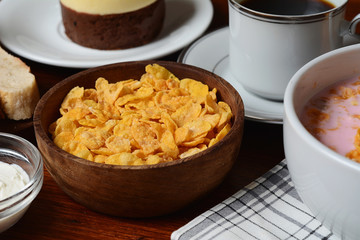 Close up of passion fruit cake, toast, coffee, yogurt, cereals.