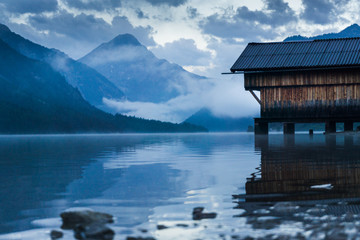 Hütte am Bergsee im Nebel