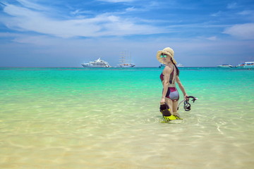 Cute girl is relaxing in the summer at the sea.Lovely girl is happy on the sand.Traveling by the sea.Beautiful sea of Thailand.