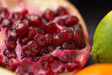 food, fruits and healthy eating concept - close up of pomegranate on stone table