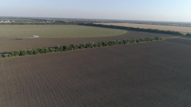 agriculture, aircraft flies over field with wheat and splashing insecticides against parasite in view from above of vintage propelled plane flies beautifully over green plantation