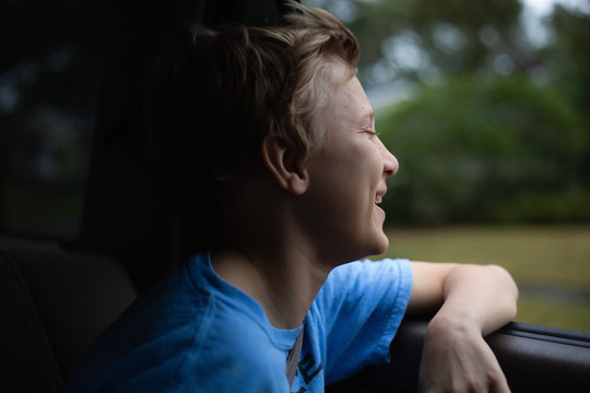 Portrait of a boy riding in a car with the window open.