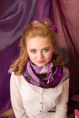 A young girl in a purple scarf looking at the camera