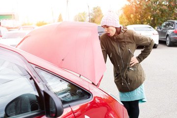 girl near the car with an open hood