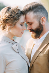 Meeting newlyweds on the bridge, lovely kisses and hugs. Wedding in nature, at sunset. Ceremony for two. Stylish modern wedding. The bride's bouquet and decor.