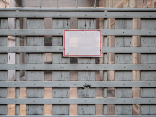 Blank white board hang on entrance gate. Empty text on attention board. Old vintage wooden fence with no people at abandoned house.