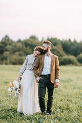 Wedding in American style, on a ranch with a horse. Walk couples in the fields at sunset, with...