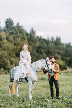 Wedding in American style, on a ranch with a horse. Walk couples in the fields at sunset, with friends and on horseback. Modern couple and ideas for the ceremony.