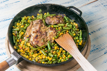 Roasted vegetables with meat in a pan.