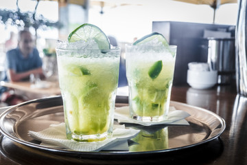 Two caipirinha cocktails on a bar counter