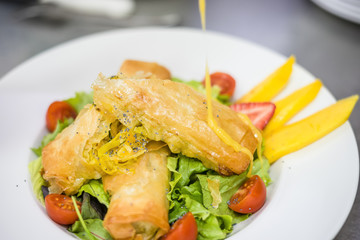 Sea food croquettes served with lettuce, cherry tomatoes and mango