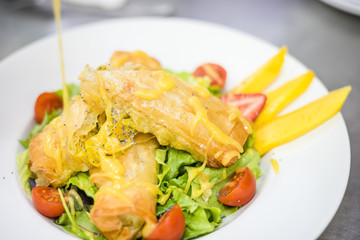 Sea food croquettes served with lettuce, cherry tomatoes and mango