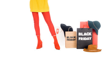 partial view of woman, hats and shopping bags with black friday inscription isolated on white
