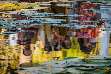 Indian women in pond reflection - India