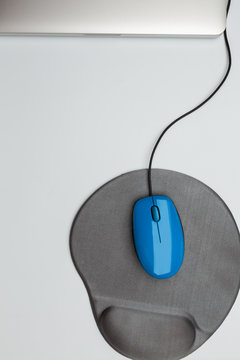 blue mouse and pad and aluminium chasis of notebook computer on white background, top view, copy space, work on computer