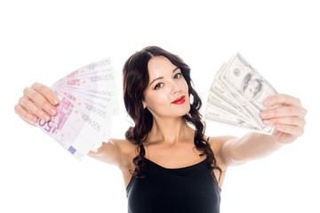 portrait of young woman showing dollar and euro banknotes in hands isolated on white