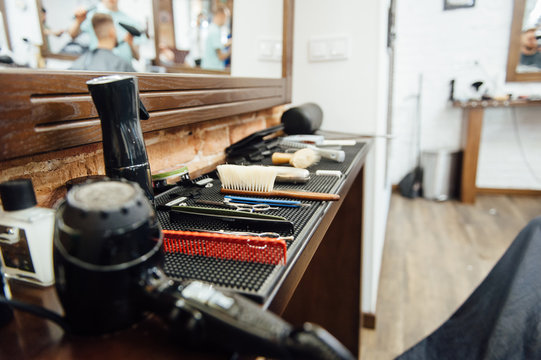 barber cutting hair with scissors. back view of man in barber shop