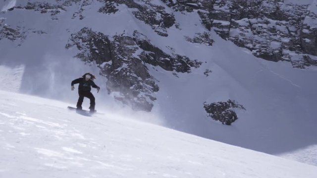 Ski resort. Snowboarder ride on slope. Spray of snow. Shake hands. Sunny day. Slow motion