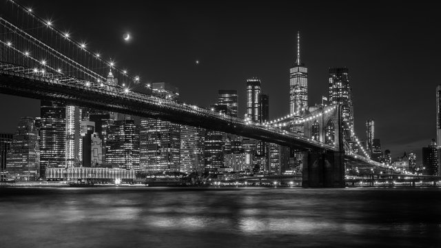 Fototapeta Brooklyn Bridge in New York mit Manhattan Skyline bei Nacht in schwarz/weiß