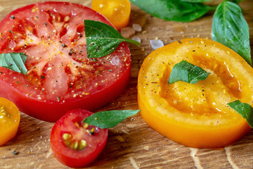 Sliced tomatoes and basil on a wooden board