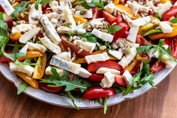 Salad with tomatoes, blue cheese, arugula and sunflower seeds