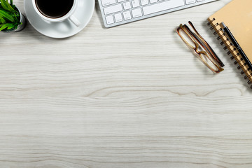 Stylish office table desk. Workspace with laptop, vintage books and coffee mug on white wooden background. Flat lay, top view